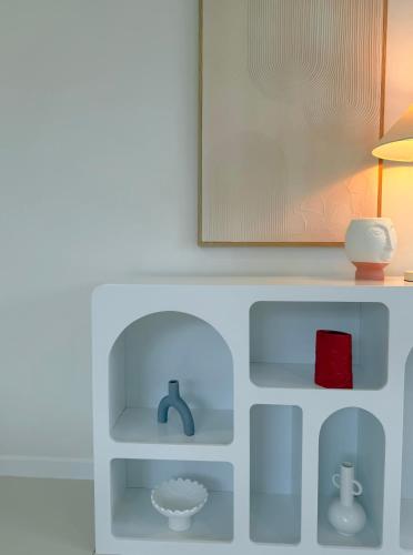 a shelf with a sink and a lamp on it at Little Santorini Retreat - Family Home near Theme Parks in Pimpama