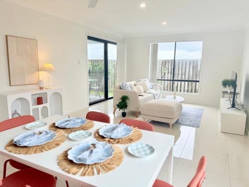 a living room with a white table and chairs at Little Santorini Retreat - Family Home near Theme Parks in Pimpama