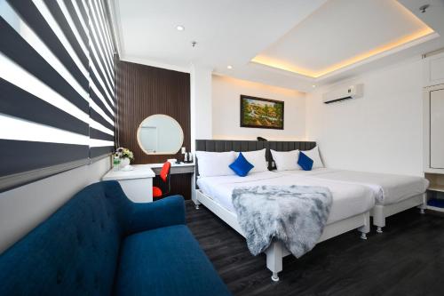 una camera d'albergo con due letti e un divano di Ruby Saigon Hotel - Ben Thanh ad Ho Chi Minh