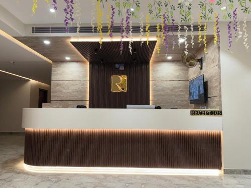 a lobby with a reception desk and purple flowers at Hotel Ratan Elite in Bijainagar