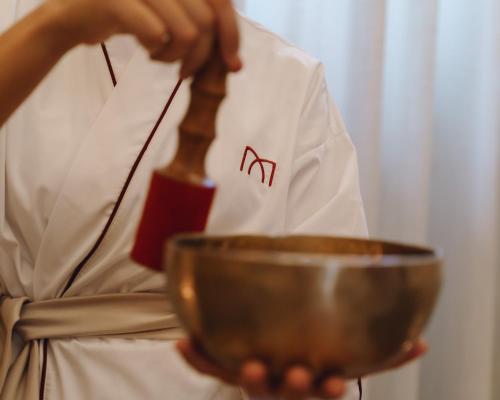 a person in a chefs uniform holding a metal bowl at La Monastica Resort & Spa in Borgo a Buggiano