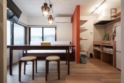 a dining room with a table and two stools at The Villa Ebisu RED惠比寿駅徒步8分静かな住宅地 in Tokyo