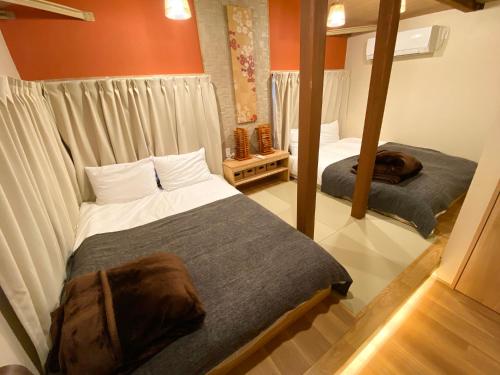 a bedroom with two beds and a mirror at The Villa Ebisu RED惠比寿駅徒步8分静かな住宅地 in Tokyo