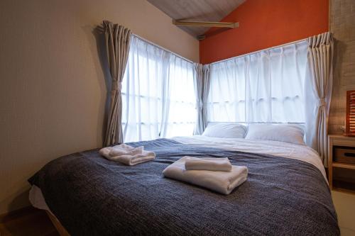 a bedroom with two towels on a bed with a window at The Villa Ebisu RED惠比寿駅徒步8分静かな住宅地 in Tokyo