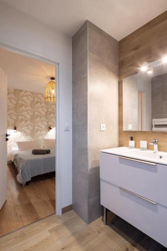 une salle de bain avec un lavabo et une chambre avec un lit dans l'établissement Villa Odet O Bord de l'O, à Combrit