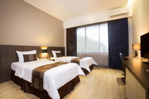 Postel nebo postele na pokoji v ubytování Grand Kecubung Hotel