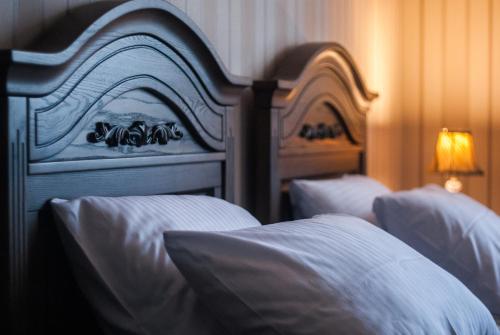two beds in a hotel room with white pillows at Aristokrat in Vinnytsya