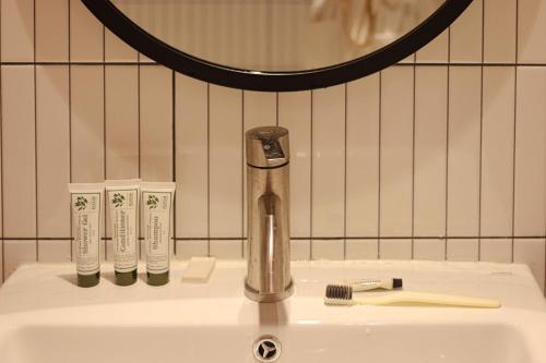 a sink with a faucet and two toothbrushes on it at lyrical Hotel Busan Yeongdo in Busan