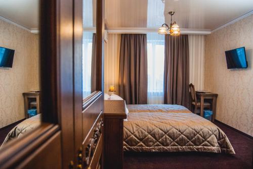 a hotel room with a bed and a mirror at Aristokrat in Vinnytsya