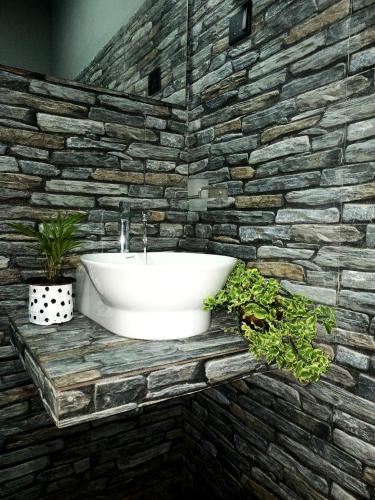 a bathroom with a sink in a stone wall at Inside Weligama in Walliwala East