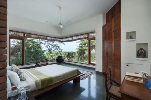 Un dormitorio con una cama y una ventana grande. en SaffronStays Pride Rock, en Mandve