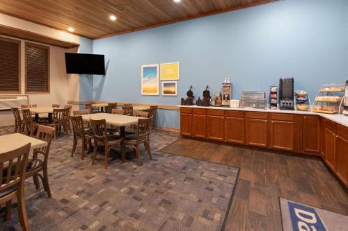 un ristorante con tavoli, sedie e un bancone di Days Inn by Wyndham Hutchinson a Hutchinson