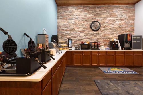 una cucina con bancone e orologio su un muro di mattoni di Days Inn by Wyndham Hutchinson a Hutchinson