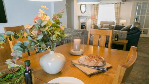 a wooden table with a vase and a plate of bread at Sailors Return in Beaumaris