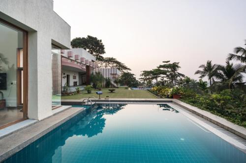 una piscina frente a una casa en SaffronStays Pride Rock, en Mandve