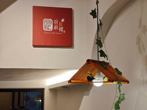 a lamp with birds on it hanging from a wall at FuqianRED in Tainan