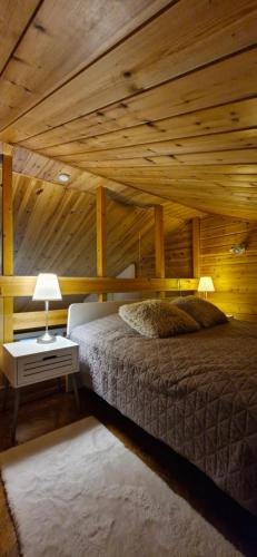 Un dormitorio con una cama y un techo de madera. en LuppoSyöte, en Syöte