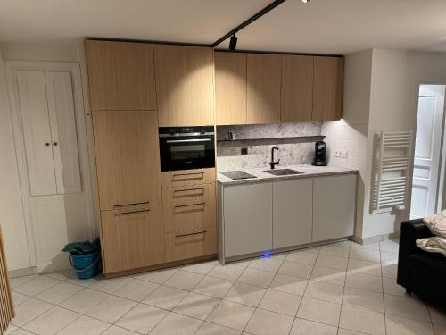 une cuisine avec des armoires en bois et un four à plaques de cuisson dans l'établissement Les 4 maisons Brides-les-Bains, à Brides-les-Bains