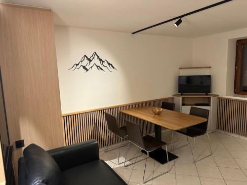 une salle à manger avec une table et une télévision dans l'établissement Les 4 maisons Brides-les-Bains, à Brides-les-Bains