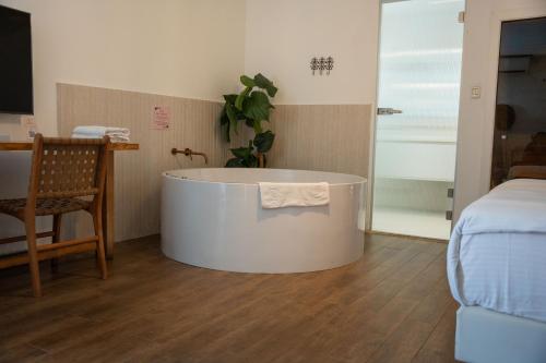 a bath tub in a room with a bed at Estate Spa Boutique Hotel - Adults Only in Rechovot