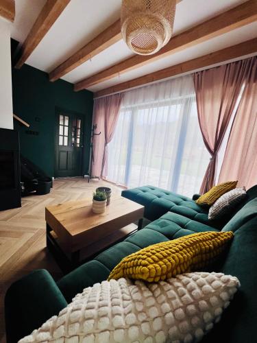 a living room with a green couch and a table at Stodoła Na Widoku in Wünschelburg