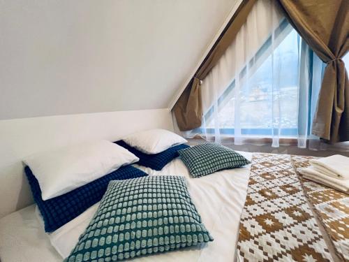 a bed in a room with two pillows on it at Stodoła Na Widoku in Wünschelburg