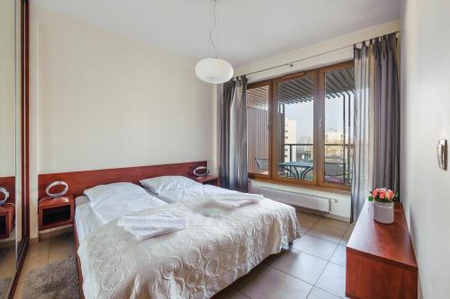 a bedroom with a bed and a large window at Olympic Park I, Sun & Snow in Kołobrzeg