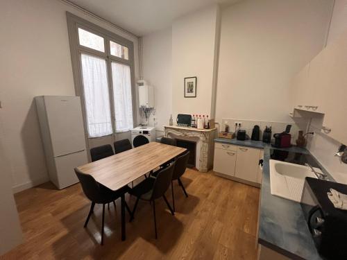 une cuisine avec une table et des chaises dans une pièce dans l'établissement Les clématites, à Narbonne
