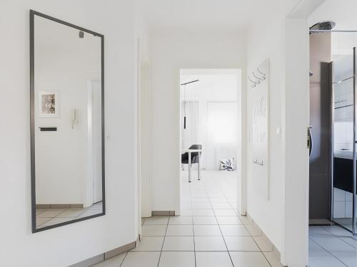 a hallway with white walls and a mirror at Ferienwohnung im Fischerhaus in Nonnenhorn