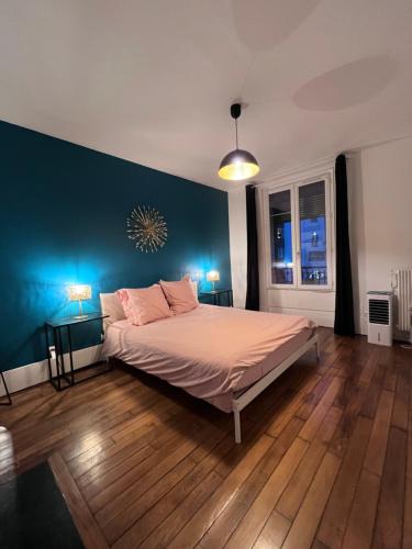 une chambre avec un lit et un mur bleu dans l'établissement Paris Eiffel Flats, à Paris