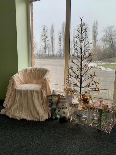 a christmas tree in a room with a couch and a christmas tree at Центр автотуризму М12 in Krasnopolka