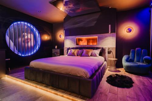 une chambre avec un grand lit et une chaise dans l'établissement Love Room Les Private Places - Lit King Size et Jacuzzi Privé, à Orléans