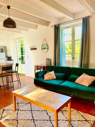 - un salon avec un canapé vert et une table basse dans l'établissement Gite La Merlandie, à Montazeau