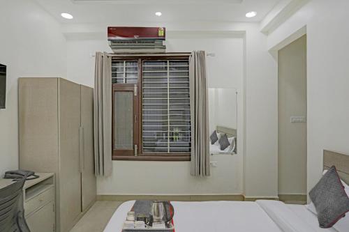 a living room with a bed and a window at Super Four Seasons in Noida