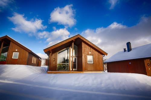 a house in the snow next to a building at Perfect Base For Skiing And Local Events in Beitostøl