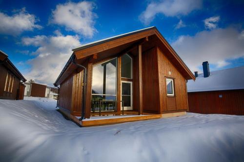 a house with a large window on top of snow at Perfect Base For Skiing And Local Events in Beitostøl