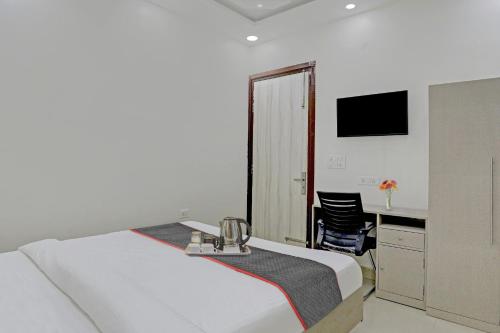a bedroom with a bed and a desk and a chair at Super Four Seasons in Noida
