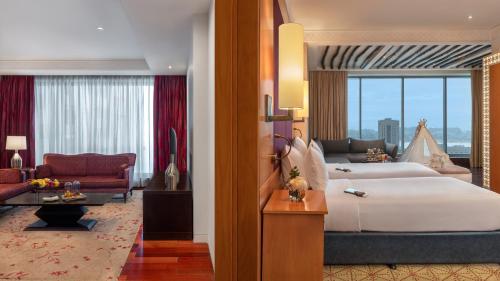 a bedroom with a large bed and a living room at The H Dubai in Dubai