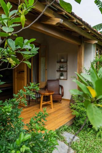 a wooden deck with a chair and a table at TOKI Cottage Đam Khê in Vũ Lâm