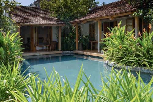 a swimming pool in front of a house at TOKI Cottage Đam Khê in Vũ Lâm