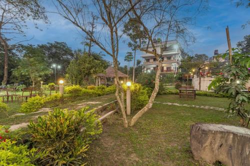a garden at night with a house in the background at Hotel Riverside with Swimming pool in Sauraha