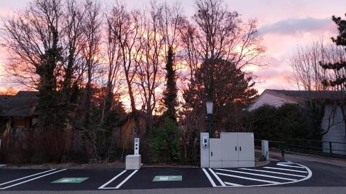 a street with a parking lot with trees and a sunset at Tennis Golf Hotel Höllrigl in Kottingbrunn