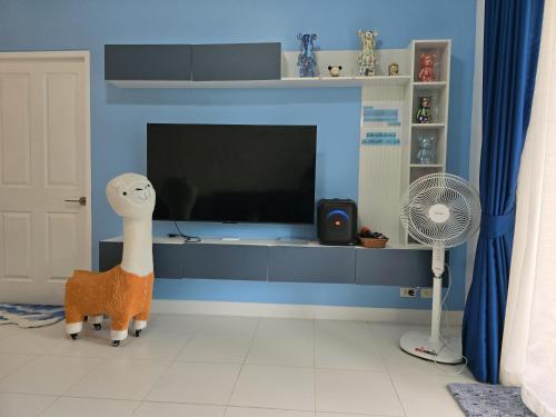 a living room with a tv and a stuffed animal at เดอรำพึง De Ramphueng ชายหาดแม่รำพึง ระยอง in Ban Chak Phai