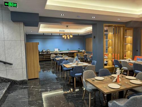 jadalnia z drewnianymi stołami i krzesłami w obiekcie Rivana Boutique Hotel w Taszkiencie
