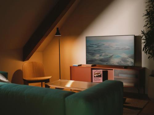 a living room with a couch and a tv at Landgasthof Riehen Hotel and Restaurant, Basel in Basel