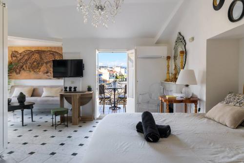 - une chambre avec un lit blanc et un salon dans l'établissement Perchoir au coeur de Nice, à Nice