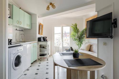 Il comprend une cuisine avec une table et une télévision murale. dans l'établissement Perchoir au coeur de Nice, à Nice