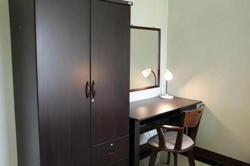 a bedroom with a desk with a mirror and a cabinet at Udoncabana in Udon Thani