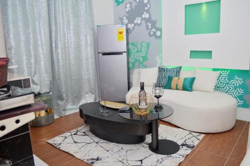 a living room with a white couch and a table at Résidence Le Sommet Douala in Douala