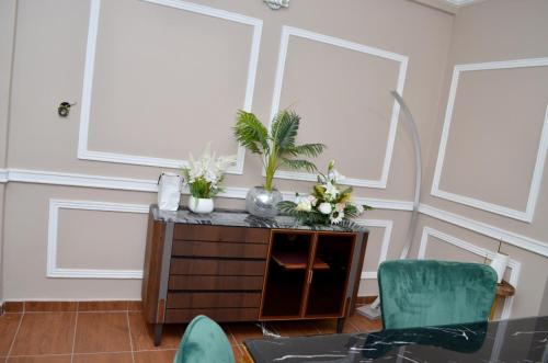 a room with two windows and a table with flowers on it at Résidence Le Sommet Douala in Douala